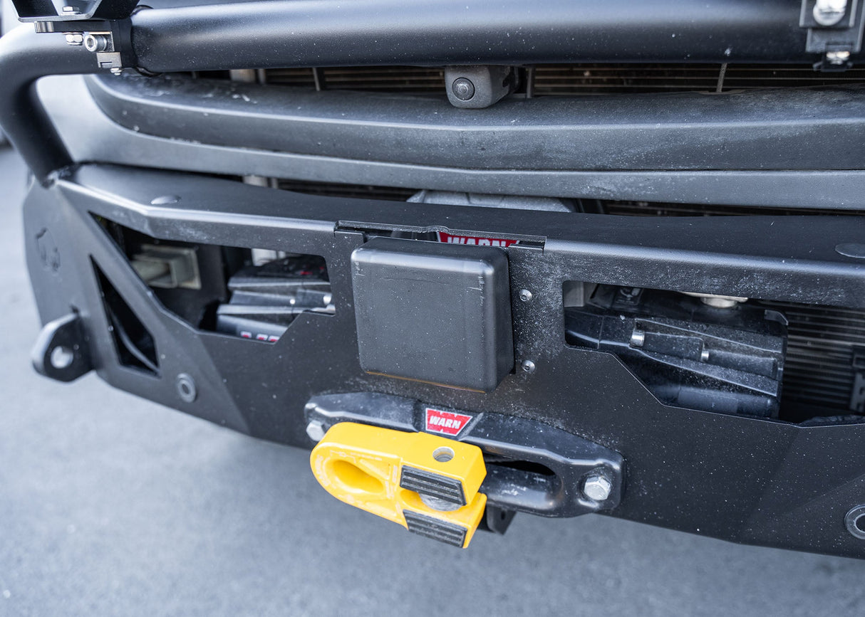 Close-up of the ROAMBUILT LoPro Front Bumper on a Mercedes-Benz Sprinter van, featuring the Warn VR-EVO winch with a hawse fairlead, integrated Active Brake Assist (ABA) sensor, and 1-inch steel shackle mounts, all encased within a lightweight 5052 aluminum shell.