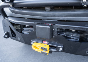 Close-up of the ROAMBUILT LoPro Front Bumper on a Mercedes-Benz Sprinter van, featuring the Warn VR-EVO winch with a hawse fairlead, integrated Active Brake Assist (ABA) sensor, and 1-inch steel shackle mounts, all encased within a lightweight 5052 aluminum shell.
