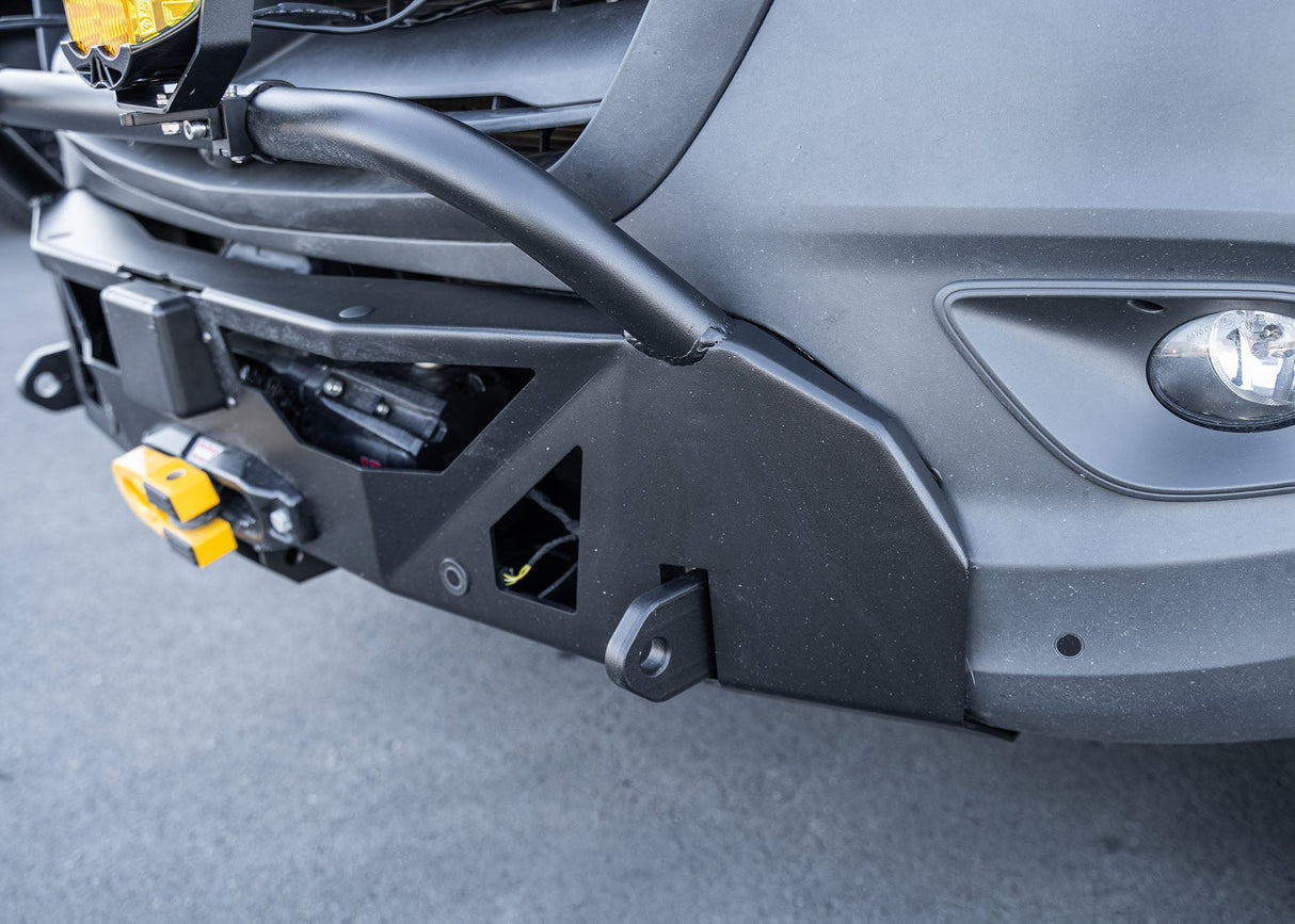 Close-up of the driver-side profile of a Mercedes-Benz Sprinter van showcasing the ROAMBUILT LoPro Front Bumper, featuring a lightweight aluminum shell, integrated bull bar, and a seamless design that adds only 3 inches of bulk while aligning precisely with the vanÄôs body lines.